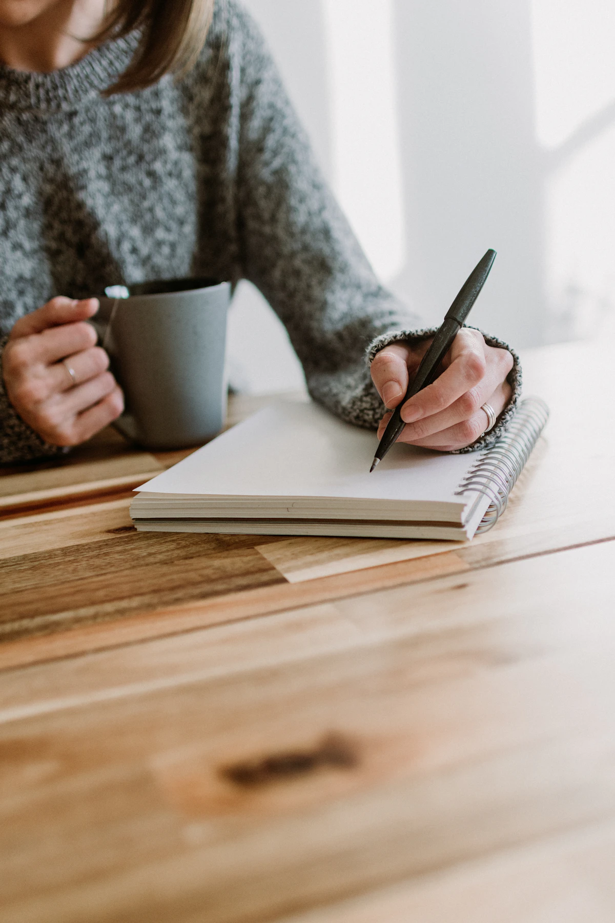 Writer taking notes in a notebook at a table